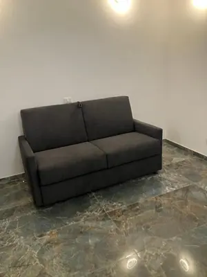 a black couch sitting in a room at Principe Umberto piano terra in Rome