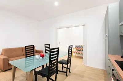 a kitchen and dining room with a glass table and chairs at Aventino Urban Place by One Up Hospitality in Rome