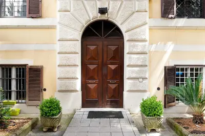 a wooden door on a building with two plants at Aventino Urban Place by One Up Hospitality in Rome