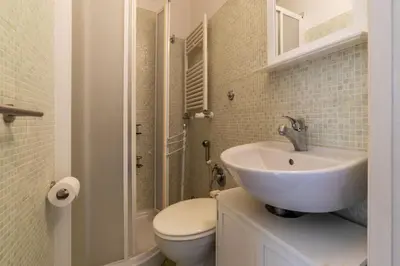 a white bathroom with a toilet and a sink at GuestHost - Comfy Apartment near Vatican City! in Rome