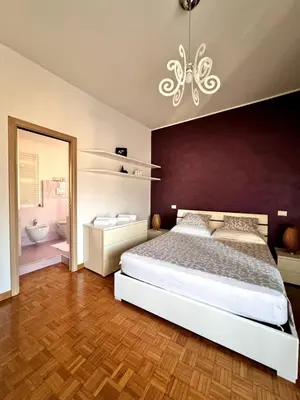 a bedroom with a large bed and a chandelier at Raffaella Vatican House in Rome