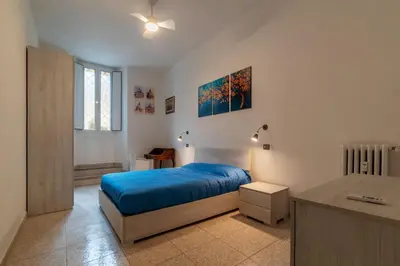 a bedroom with a blue bed and a desk at GuestHost - Piazzale Clodio Apartment in Rome