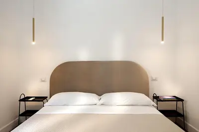 a bed with two pillows in a bedroom with two side tables at Charme Holidays Puccini in Rome