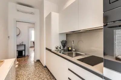 a kitchen with white cabinets and a sink at Clodio Guest House in Rome