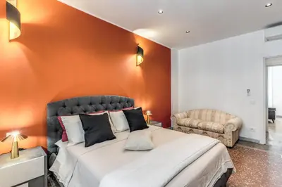 a bedroom with a large bed with an orange wall at Clodio Guest House in Rome