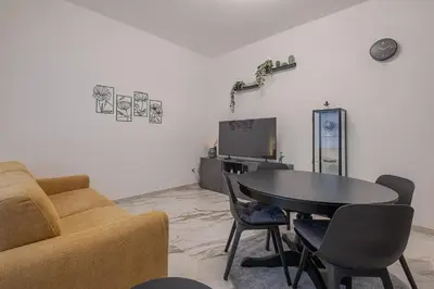 a living room with a table and chairs and a tv at Petit House Roma in Rome