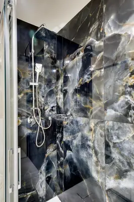 a bathroom with a black and white marble wall at Dimora Merulana 183 in Rome
