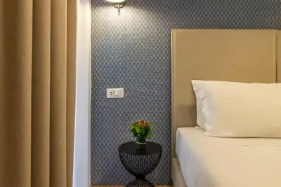 a bedroom with a bed and a vase with flowers on a table at Essence Collection Hotel in Rome