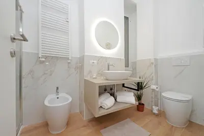 a white bathroom with a sink and a toilet at Makà 32 in Rome
