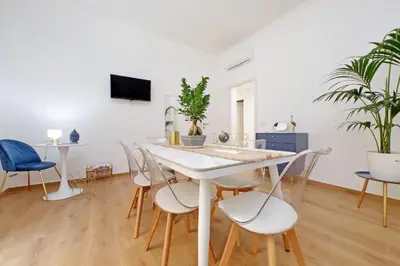 a dining room with a white table and chairs at Makà 32 in Rome