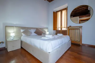a large white bed in a room with a mirror at Trevi Room in Rome