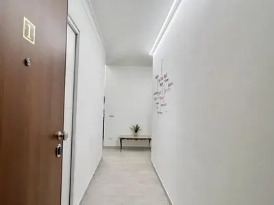 a hallway with a table and a white wall at Stylish Apartment near Trastevere in Rome