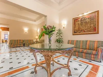 a living room with a table with a vase of flowers at Raeli Hotel Noto in Rome