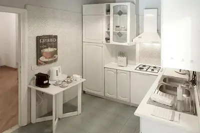 a white kitchen with white cabinets and a sink at Nido degli Artisti in Trastevere Piazza Trilussa in Rome