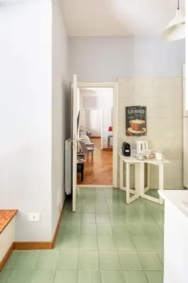 a kitchen with a refrigerator and a table in it at Nido degli Artisti in Trastevere Piazza Trilussa in Rome