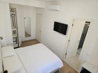 a white room with a bed and a flat screen tv at Toto San Paolo Rooms in Rome
