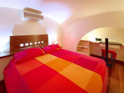 a bedroom with a colorful bed and a desk at Sweet Home Colosseum in Rome