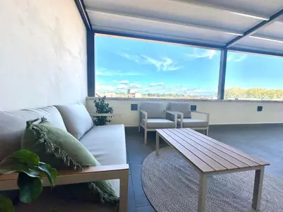a living room with a couch and a table at Beautiful Penthouse Roma in Rome