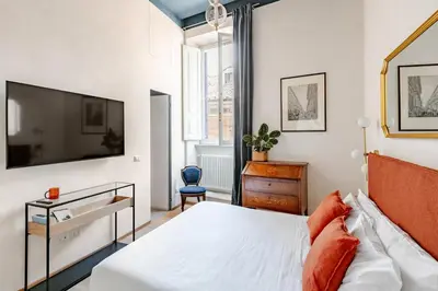 a bedroom with a bed and a tv on a wall at Unique Piazza Navona 2 Bedrooms and Home Cinema in Rome