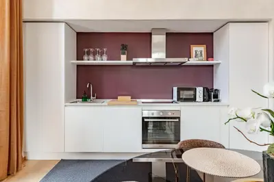 a kitchen with white cabinets and a table at Unique Piazza Navona 2 Bedrooms and Home Cinema in Rome
