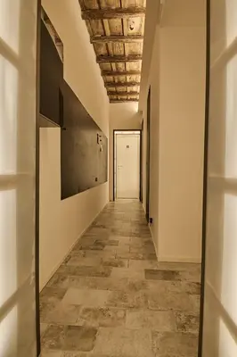 an empty corridor with a white door and a tile floor at BellaRoma NAVONA Guest house in Rome