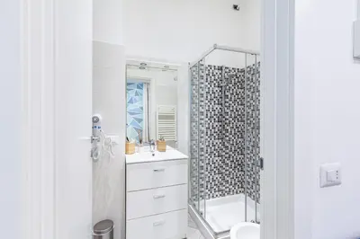 a white bathroom with a sink and a shower at Alloggi Costantini - Ospedale Gemelli - Metro Battistini in Rome