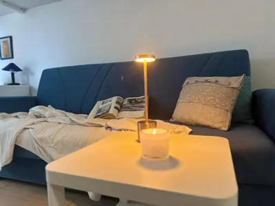 a lamp on a table in front of a blue couch at Silvestri206 in Rome