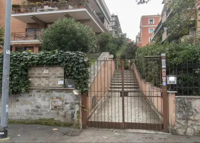 an iron gate with stairs in front of a building at Mother House in Rome