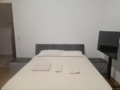 a bed with white sheets and a television in a room at Mother House in Rome