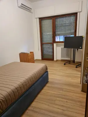 a bedroom with a bed and a flat screen tv at Mother House in Rome