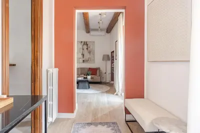 a living room with orange walls and a hallway at Piazza di Spagna 2 Bedrooms and 5 Juliet Balcony in Rome