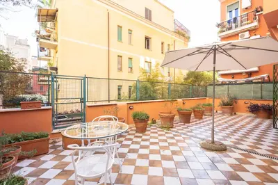 a patio with a table and an umbrella at Casa Donna Olimpia Pamphilj in Rome