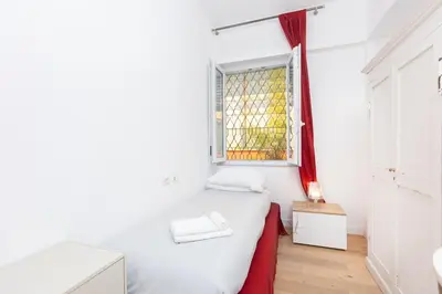 a small bedroom with a white bed and a window at Casa Donna Olimpia Pamphilj in Rome