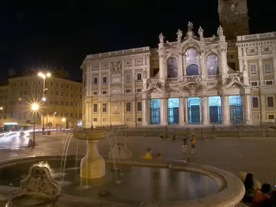 a building with a fountain in front of it at night at Casa Di Camilla in Rome