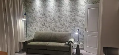 a living room with a chair and a wall at Roma Suite Style in Rome