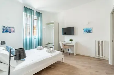 a white bedroom with a bed and a desk at iFlat Stylish New Flat Steps from the Vatican in Rome
