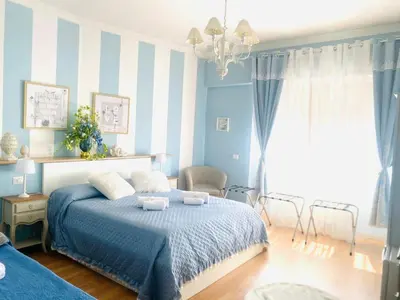 a blue bedroom with a bed and a chandelier at Mami Guest House Rome Vatican St Peters in Rome
