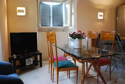 a dining room with a glass table and chairs at Appartamento Piazza Farnese in Rome
