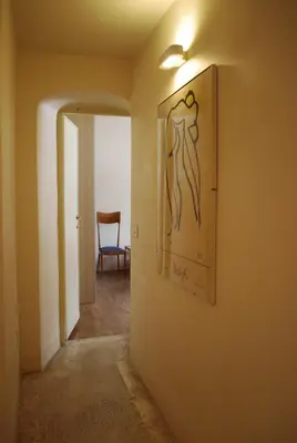 a hallway with a painting on the wall and a chair at Appartamento Piazza Farnese in Rome