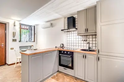 a kitchen with white cabinets and a sink at Link Campus Apartment in Rome