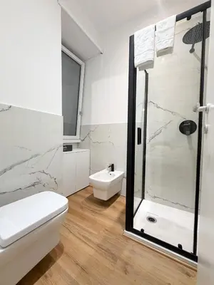 a white bathroom with a shower and a toilet at Riboty Boutique Rooms in Rome
