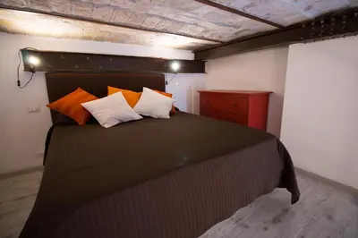 a bedroom with a black bed with orange and white pillows at Inner House in Rome