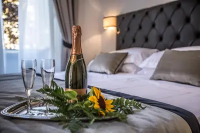 a bottle of champagne on a table with two glasses at San Pietro Leisure and Luxury in Rome