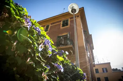 a building with purple flowers in front of a street light at San Pietro Leisure and Luxury in Rome