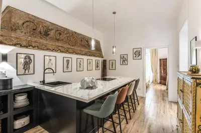 a kitchen with a large counter with chairs and a sink at BoHo Studio & Terrace in Rome