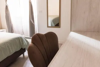 a bedroom with a chair next to a bed at Comfort Suite Balduina - Rome in Rome