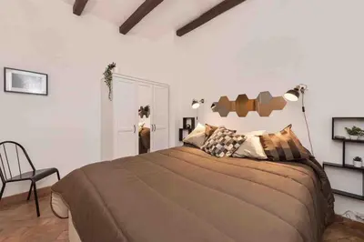 a bedroom with a large bed and a chair at Gianicolo Maison nel cuore di Roma in Rome