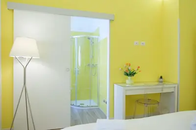 a bathroom with a shower and a table with a lamp at RainbHome Colourful Roman Suites in Rome
