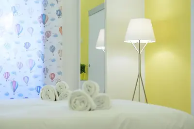 a bedroom with a bed with a lamp and a mirror at RainbHome Colourful Roman Suites in Rome