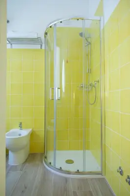 a glass shower in a bathroom with a toilet at RainbHome Colourful Roman Suites in Rome
